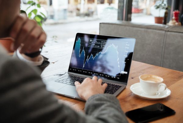 Homem acompanhando os indicadores logísticos da supply chain em um notebook enquanto toma café