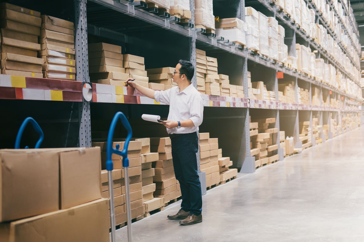 homem em um estoque organizando produtos de forma estratégica