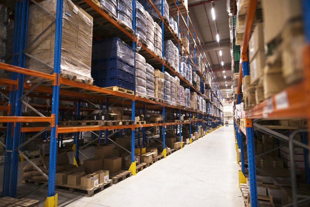 interior de grande armazem de distribuicao com prateleiras repletas de paletas e produtos prontos para o mercado